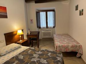 a bedroom with two beds and a desk and a window at L'Antica Torre Caralis Holiday in Cagliari