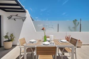 a dining table with chairs and a whale on a wall at Callao Beach 7 in Arrieta