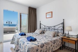 Un dormitorio con una cama con toallas azules. en Callao Beach 7 en Arrieta