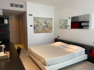 ein Schlafzimmer mit einem großen Bett und einem Schreibtisch in der Unterkunft Blue Shades ApartHotel in Pisa