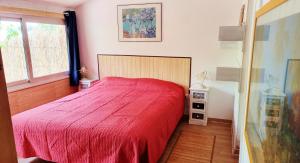 a bedroom with a red bed and a window at Sunset Valley Village in Motta SantʼAnastasia