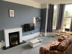un soggiorno con divano e camino di Well-appointed apartment in New Brighton a New Brighton