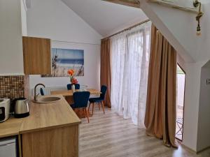 a kitchen and dining room with a table and chairs at ORI Orange Studio Malul Mureșului in Arad