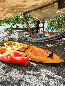 un groupe de kayaks assis au sol sous une table dans l'établissement Plézi Location F3 au bord de mer, Trois-Ilets, à Les Trois-Îlets