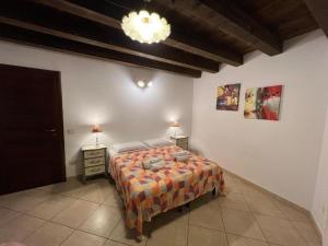 a bedroom with a bed and a chandelier at L'Antica Torre Caralis Holiday in Cagliari