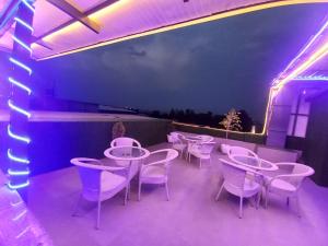 un grupo de mesas y sillas en un patio con luces púrpuras en HOTEL BLUE ORCHID - A 3 STAR HEAVEN IN Tricity, en Zirakpur
