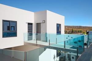 une maison en verre avec une piscine dans l'établissement Callao Beach 10, à Arrieta