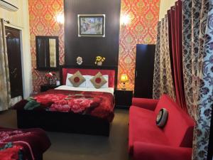 a bedroom with a red bed and a red chair at Hotel Royal Fort in Lahore