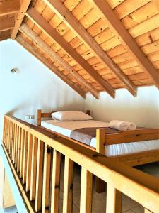 Cama elevada en habitación con techo de madera en Garden House No 2, en Plomari