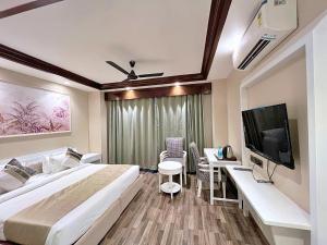 a hotel room with a large bed and a tv at Skon Boutique by Orion Hotels in New Delhi