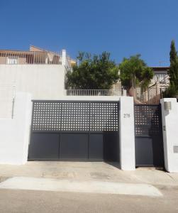 a black garage door with a white fence at LAS PALOMAS, appartement 2 chambres avec piscine in Turís