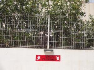 a red sign on the side of a fence at LAS PALOMAS, appartement 2 chambres avec piscine in Turís