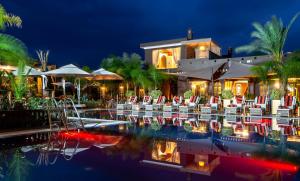 a resort with a pool with chairs and a building at The Lemonary Marrakech in Marrakesh