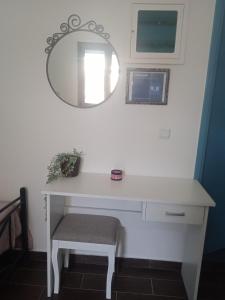 a white desk with a chair and a mirror at Ag.apostoloi studios in Agioi Apostoli