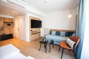pokój hotelowy z łóżkiem i telewizorem w obiekcie Ascona Lodge, Pool & Garden Retreat w mieście Ascona