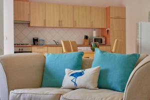 a couch with two blue pillows in a kitchen at Apartamento T3 encantador com piscina wifi e perto de praia in Santa Maria