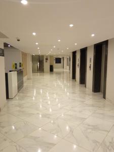 an empty hallway with white marble floors and lights at Elegant and comfy apartment in Westlands, Nairobi in Nairobi