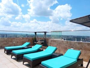 a balcony with blue chairs and a view of the city at Elegant and comfy apartment in Westlands, Nairobi in Nairobi