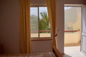 1 dormitorio con ventana y vistas a una palmera en Apartamento T3 encantador com piscina wifi e perto de praia, en Santa Maria 39 fotos más
