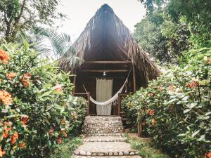 a wooden building with a hammock in front of it at Cabaña Wiwa Tayrona in Santa Marta