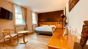 a bedroom with a bed and a desk and a table at Salischer Hof in Schifferstadt