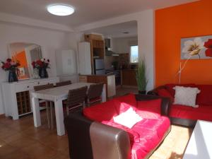 a living room with a red couch and a table at LAS PALOMAS, appartement 2 chambres avec piscine in Turís