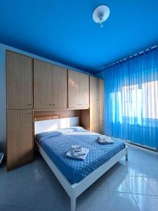 1 dormitorio con 1 cama con techo azul en Affittacamere I Gigli di Mare, en Marina di Bibbona