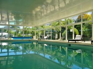 uma casa com piscina e muitas janelas em Skyblue Apart Hotel Punta Colorada em Piriápolis