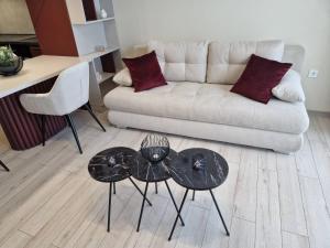 sala de estar con 2 mesas y sofá en PAPAYA APARTMENTS, en Varna