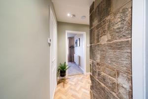 a hallway with a stone wall and a brick wall at Clubhouse Cottage on Eden View Estate in St Andrews