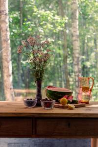 stół z wazonem, owocami i kwiatami w obiekcie Tu, Tam i Tamten Domek w mieście Wojtyniów