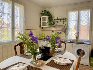 的住宿－Etage privé dans Maison de Maître，厨房配有一张带紫色鲜花的桌子