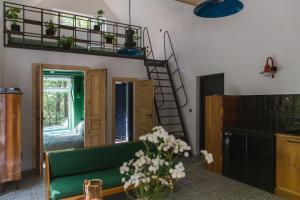 a living room with a green couch and a staircase at Tu, Tam i Tamten Domek in Wojtyniów