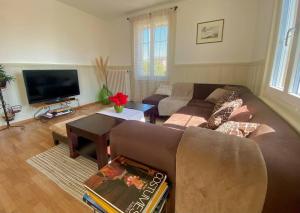 a living room with a couch and a tv at Etage privé dans Maison de Maître 