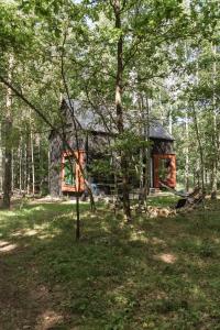 a log cabin in the middle of a forest at Tu, Tam i Tamten Domek in Wojtyniów