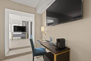 a hotel room with a desk with a tv and a chair at Hotel Zentral Ramiro I Oviedo in Oviedo