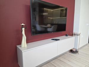 uma televisão em cima de uma cómoda branca num quarto em PAPAYA APARTMENTS em Varna