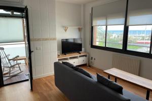 uma sala de estar com um sofá e uma televisão de ecrã plano em Apartment with sea views next to the beach of Mar Bella em Barcelona