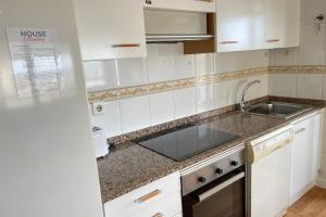 una cocina con armarios blancos y fregadero en Apartment with sea views next to the beach of Mar Bella, en Barcelona