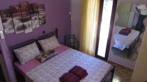 1 dormitorio con 1 cama con paredes de color púrpura y espejo en Nightflower rooms en Sami