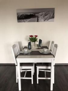 a white table and chairs with a table and flowers at Rudi in Wieck