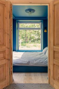 a bedroom with a window and a bed in a room at Tu, Tam i Tamten Domek in Wojtyniów
