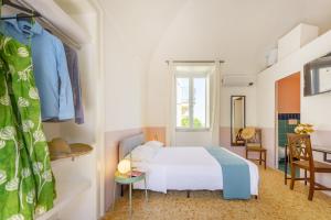 um quarto com uma cama branca e uma secretária em Olivieri 25 - Gioia Apartments em Procida