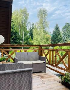 un patio con 2 sillas de mimbre en una terraza de madera en Apartament Turystyczna 22, en Szklarska Poręba