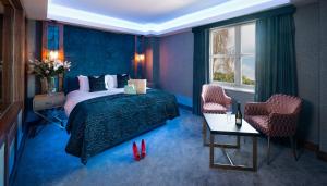 a bedroom with a bed and two chairs and a table at Midlands Park Hotel in Portlaoise