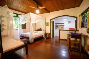 a bedroom with a bed with a mosquito net at Anjali in Ilha de Boipeba