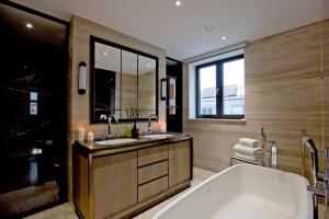 a bathroom with two sinks and a bath tub at 37GS Residences in London