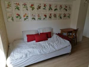Schlafzimmer mit einem Bett mit roten Kissen und einem Tisch in der Unterkunft LE SEIZE - Gîte 4 personnes - entre Caen et la mer in Cairon