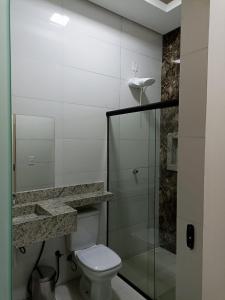 a bathroom with a toilet and a glass shower at PIRANHAS HOTEL in Piranhas