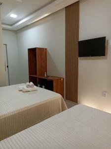 PIRANHAS HOTEL في ببرانا: غرفة فندقية بسريرين وتلفزيون بشاشة مسطحة